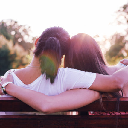 Two people embraced on a park bench.